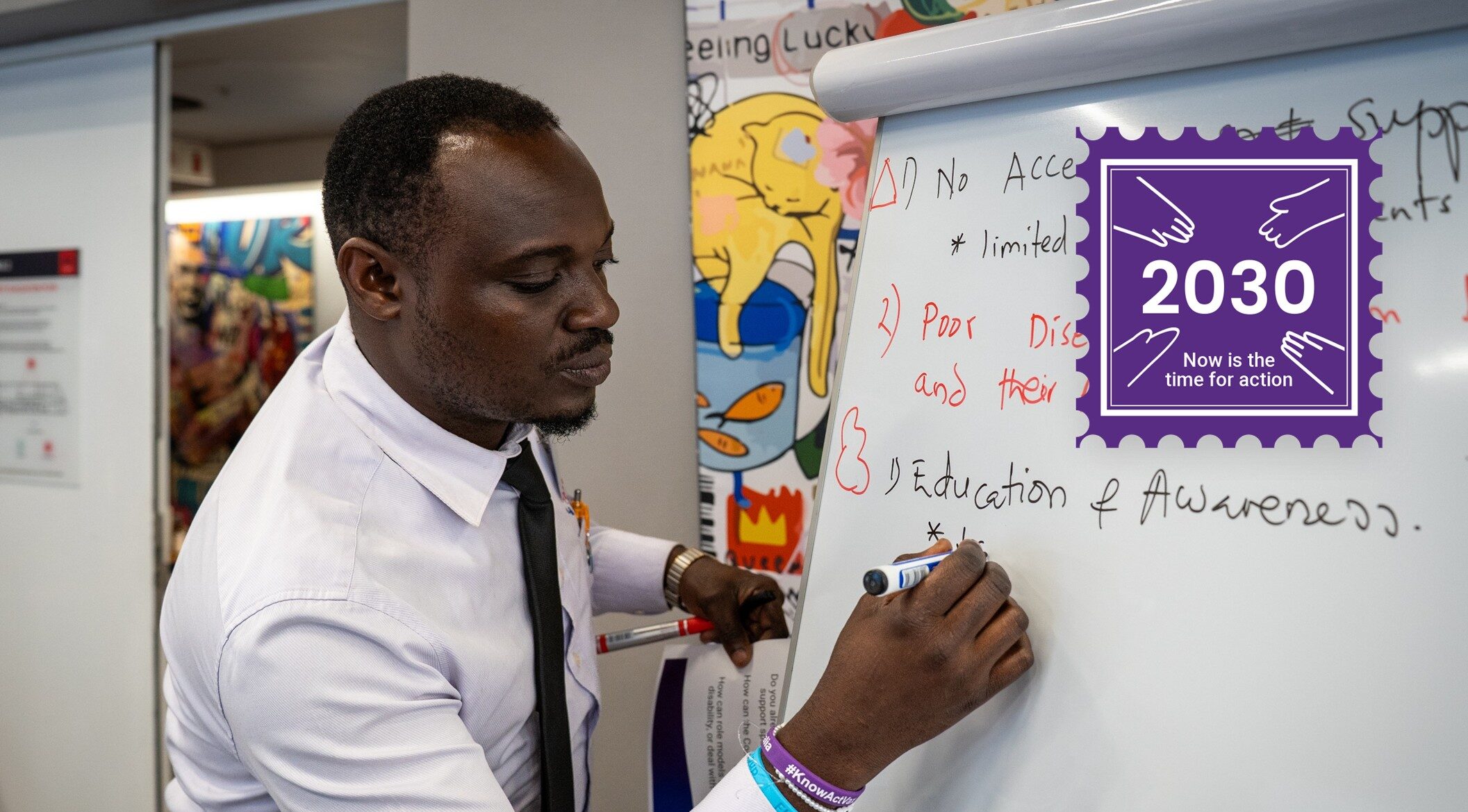A man writing on a whiteboard. He has written 