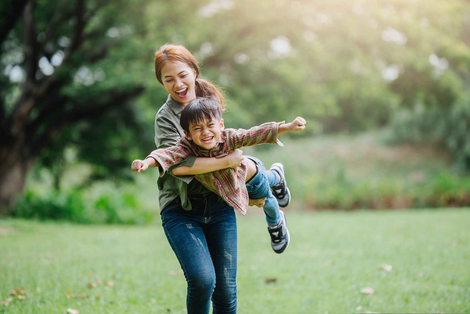 A woman and a child playing in a field.