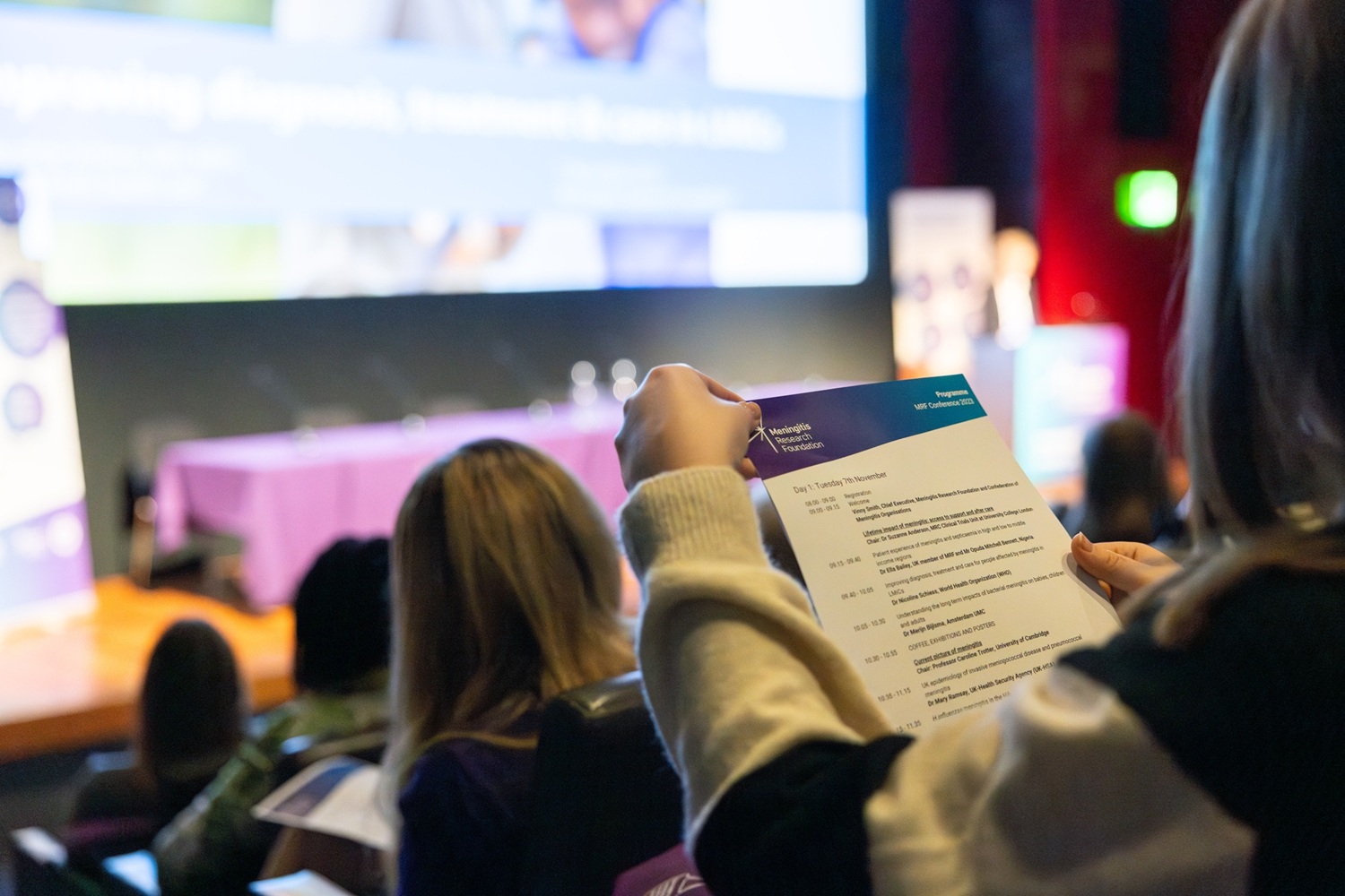 A conference delegate reading a programme.