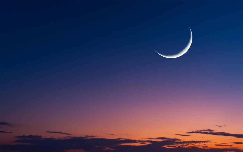 An image of the night sky with a crescent moon.