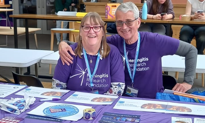 Two Meningitis Research Foundation Ambassadors sitting at a table.