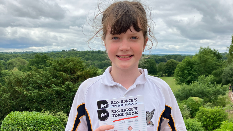 Maddie Davies smiling holding Big Eddie's Joke Book.