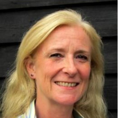 A headshot of Caroline Mackrill, a blonde woman wearing a green and white shirt.
