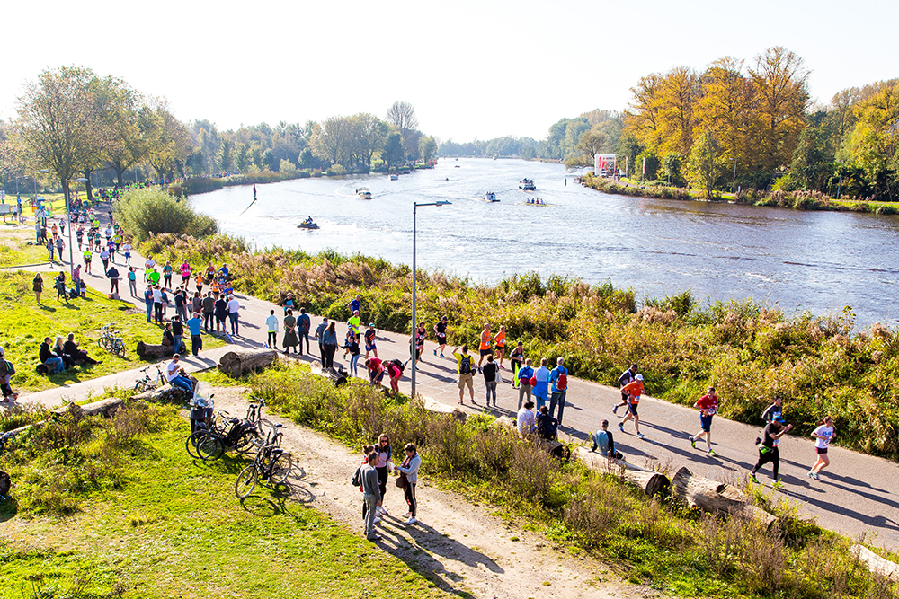 Group of people running alongside through Vondelpark in Amsterdam.