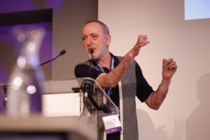 A man speaking into a microphone behind a podium